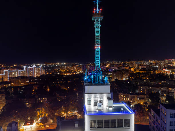 Aerial night view on Derzhprom building rooftop with antenna and illuminated Kharkiv city, Ukraine