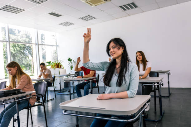 istock Female student raising her hand in class to ask some question 2167952646