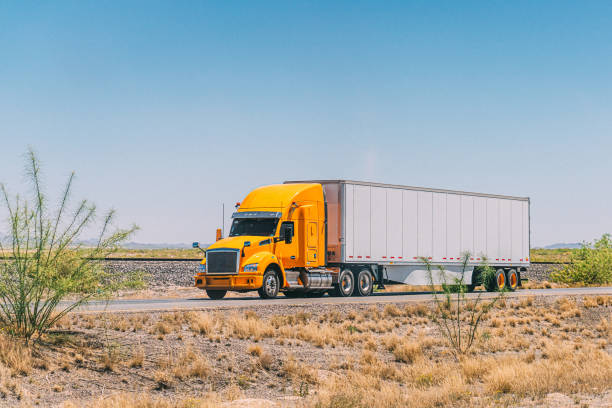 istock Bright Yellow Semi Truck pulling a Plain White Trailer on a Sunny Day in Chihuahua State, Mexico 2167953283