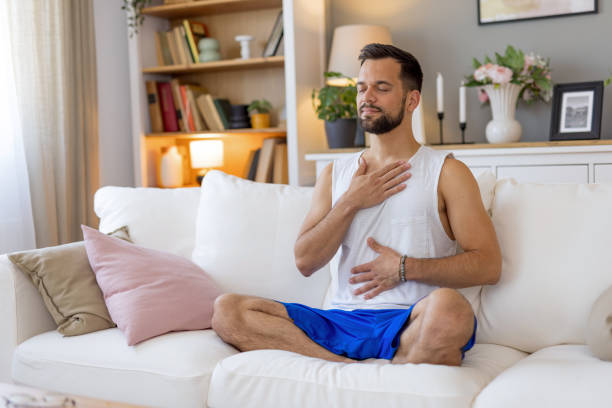 Person meditating with hands on chest and stomach.