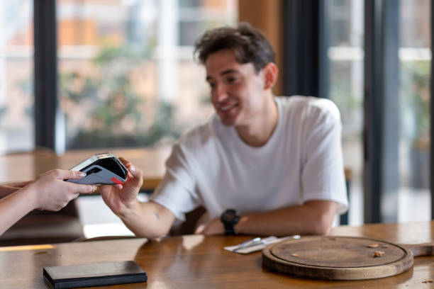 istock Young man making contactless payment with credit card in restaurant 2167957366