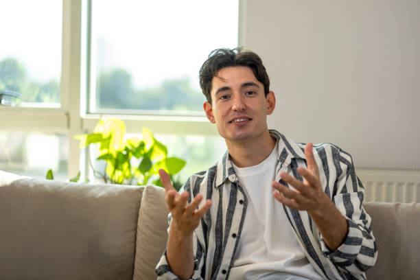 istock Young man looking at camera and talking at home 2167957511
