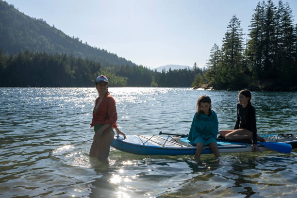 istock Mother and daughters SUP on lake 2167957957