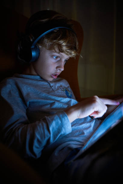istock Boy playing on tablet in murk room 2167959722