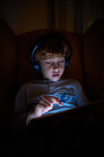 istock Boy playing game on tablet in darkness 2167959730