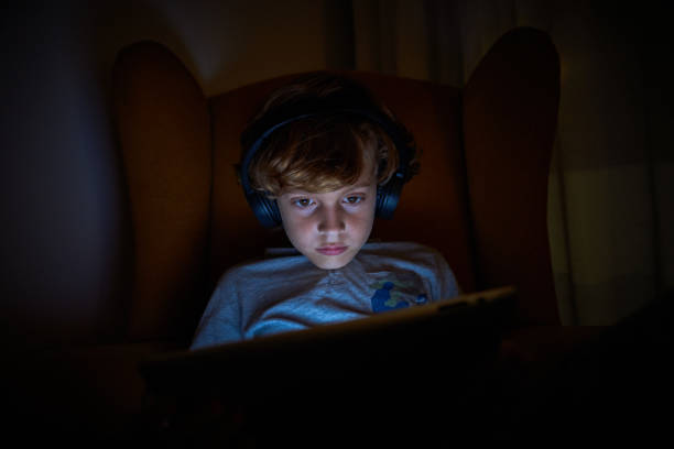 istock Boy playing on tablet in obscure room 2167959753