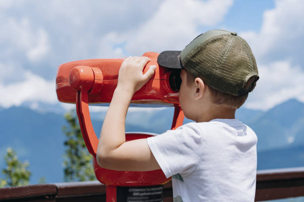 istock boy observing mountains panorama through stationary binoculars 2167962431