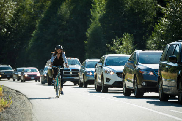 istock Woman commutes by bicycle past traffic 2167962658