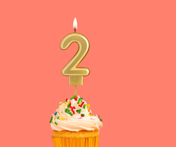 istock Birthday number 2 - Golden candle with cupcake 2167962802