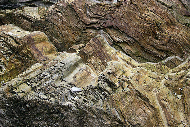 Layered rock formations with intricate stone textures, revealing the mountain's geological history. The abstract patterns create a textured background, highlighting the complexity of rock layers.