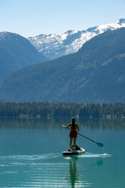 istock Woman SUP boards across mountain lake 2167965553