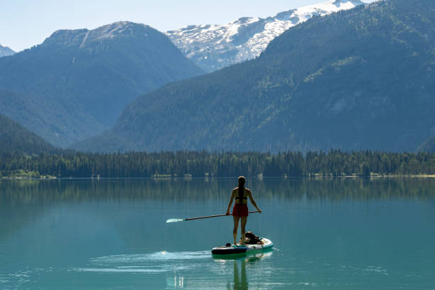 istock Woman SUP boards across mountain lake 2167965554