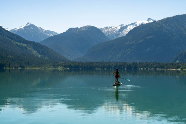 istock Woman SUP boards across mountain lake 2167965563