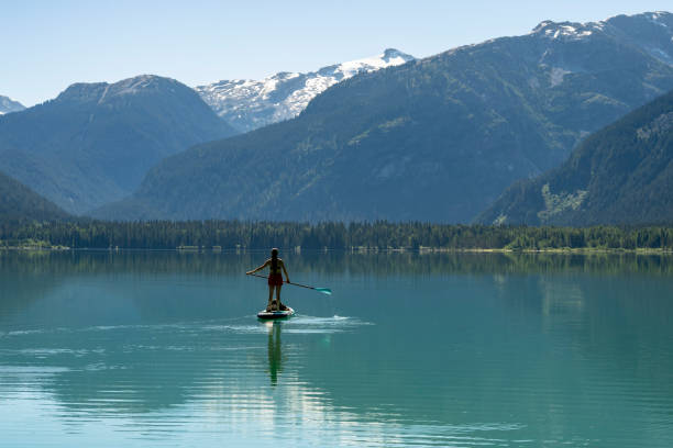 istock Woman SUP boards across mountain lake 2167965584