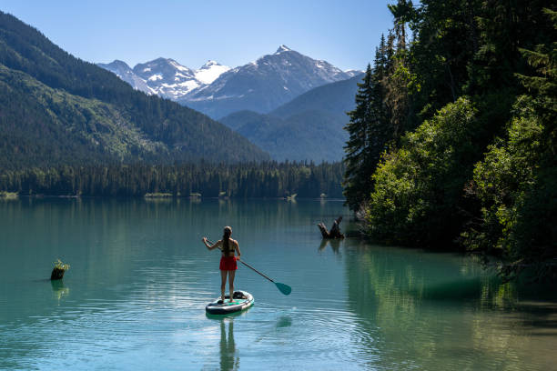 istock Woman SUP boards across mountain lake 2167965615