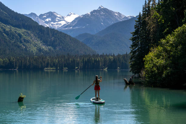 istock Woman SUP boards across mountain lake 2167965616