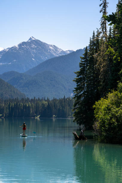 istock Woman SUP boards across mountain lake 2167965676