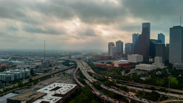 istock Rush hour traffic navigates Houston Downtown. Stormy skies cast dramatic backdrop over skyscrapers and Gulf Freeway 2167966118