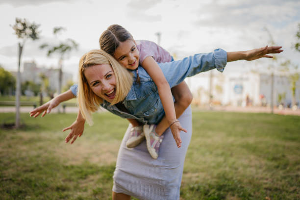 Little girl enjoying a sunny day in the park with her mom