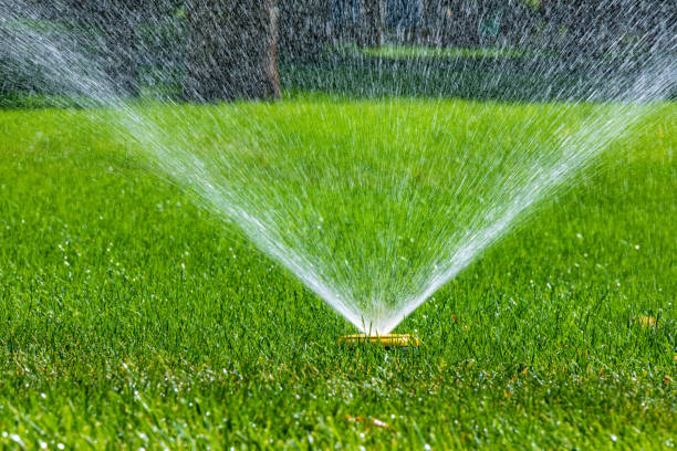 istock Flying splashes of water on green grass. Sprinkler Irrigation system for watering a lawn 2167967708