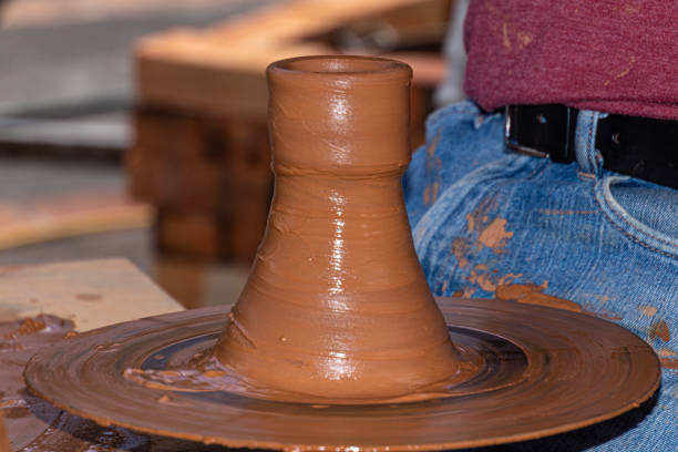 The process of forming a jug from raw clay in a workshop on a potter's wheel