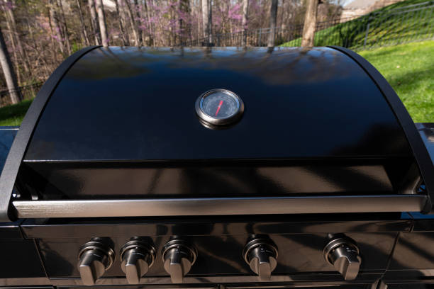 Pair of hands checking a barbecue at a home in Ontario.