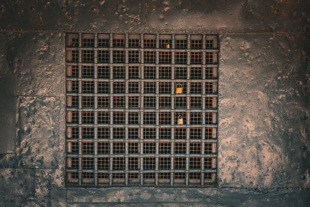 iron bars with locked padlocks in a window with metal wall