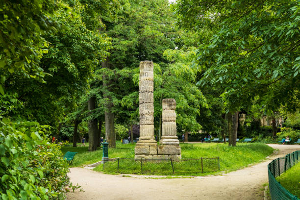 Paris, France - May 27, 2024: Ancient stone columns stand tall amidst the lush greenery of Parc Monceau, offering a serene escape in the heart of Paris, France