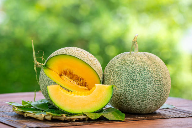 istock Orange Melon on blurred greenery background, Orange Melon or Cantaloupe fruit in Bamboo mat on wooden table in garden. 2167983152