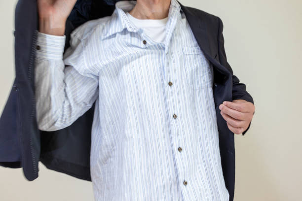 A man wearing a black jacket over a shirt