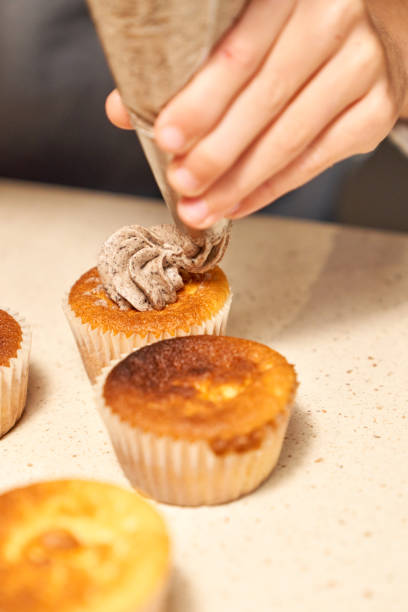 istock Crop person decorating cupcakes with cream 2167989523
