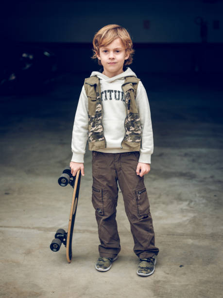 istock Child with skateboard standing on street 2167990100