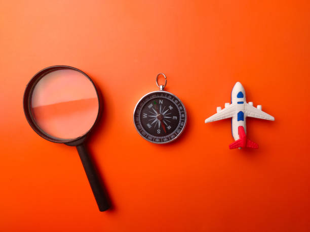 istock Magnifying glass,compass and toy plane on an orange background 2167990286