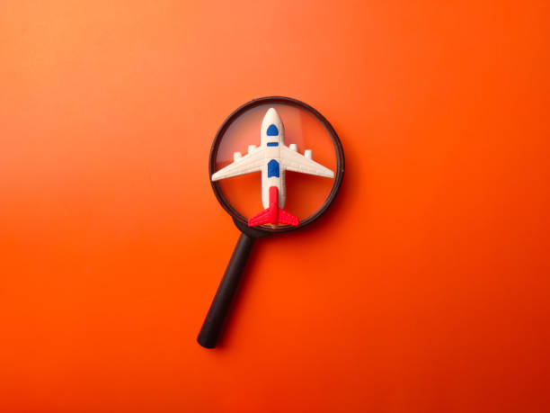 istock Magnifying glass and toy plane on a orange background 2167990304