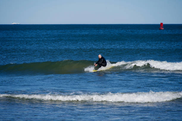 Deal, New Jersey - August 10, 2024: surfers surf the remnants of Hurricane Debby in the waters off Deal