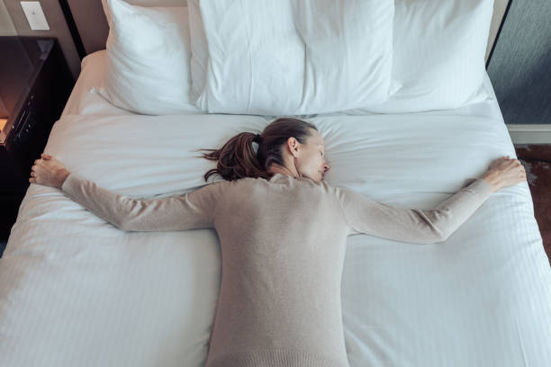 istock Young happy woman lying on a soft cozy hotel bed. 2167992012
