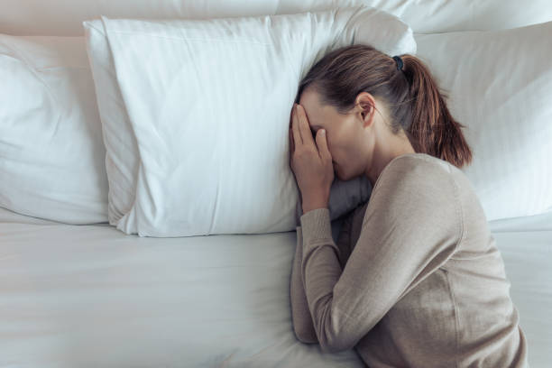 istock Stressed depressed sad woman lying in bed feeling lonely. 2167992049