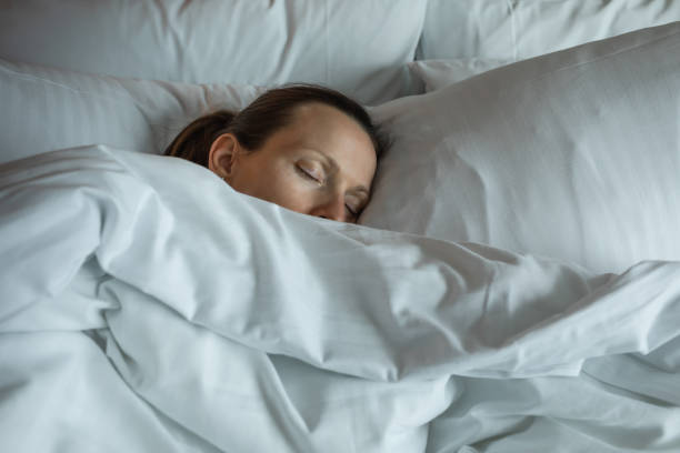 istock Young woman sleeping in bed, person in a deep sleep. 2167992052