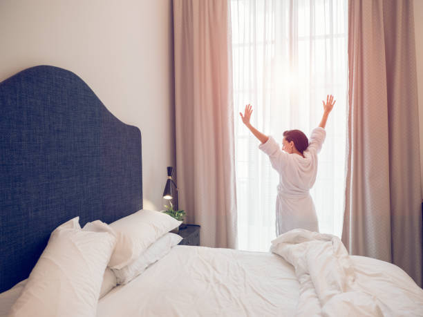 istock Anonymous woman waking up in hotel bedroom 2167992399