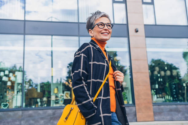 Portrait of nice aged woman handbag look away walk downtown street outdoors Portrait of nice aged woman handbag look away walk downtown street outdoors. older woman purse stock pictures, royalty-free photos & images