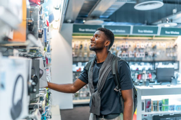 istock Young african man in a tech store looking at headphones 2168005026
