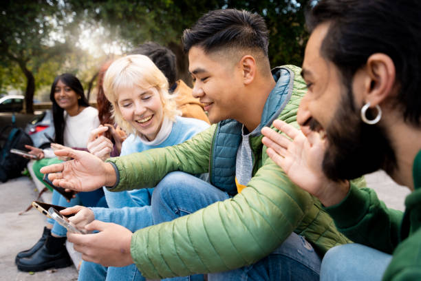 istock Diverse friends sharing smartphone outdoors, multicultural youth laughing, social connection, technology use, inclusive friendship, urban lifestyle 2168007793