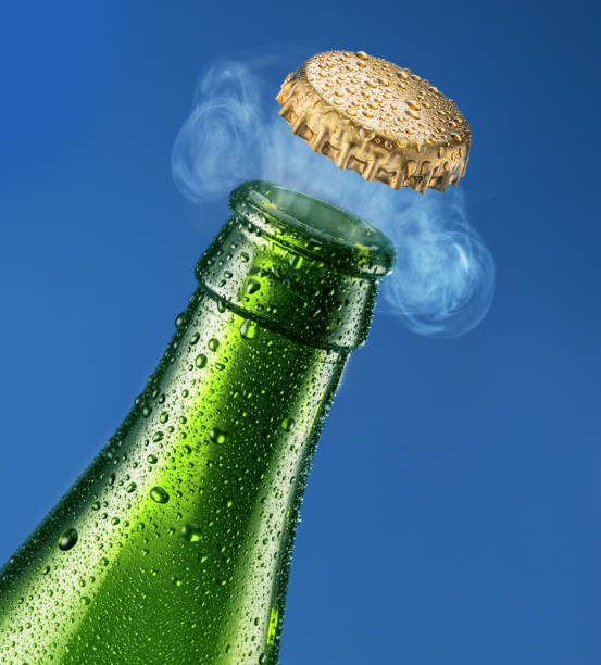 istock Opening beer bottle on blue background. Gas impurring from the beer bottle and blows cap off. 2168008546