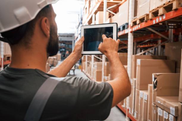 istock Using the digital tablet. Foreman is in the storehouse, shipping distribution business 2168011180