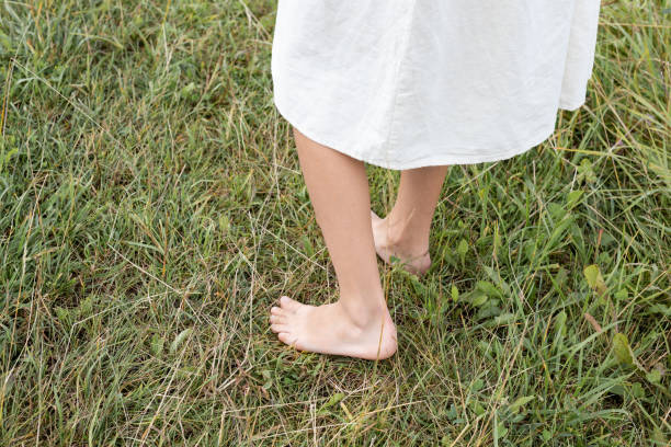istock Girl walking barefoot on green grass, closeup 2168011406