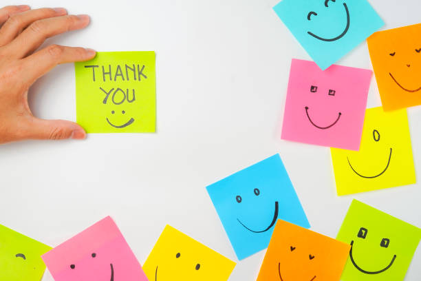 istock Thank you and smile icon inspirational handwriting on sticky notes on hand held 2168016067