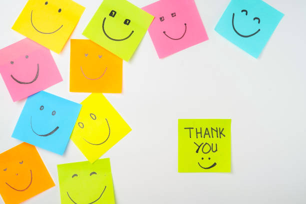 istock Thank you and smile icon inspirational handwriting on sticky notes on hand held 2168016078