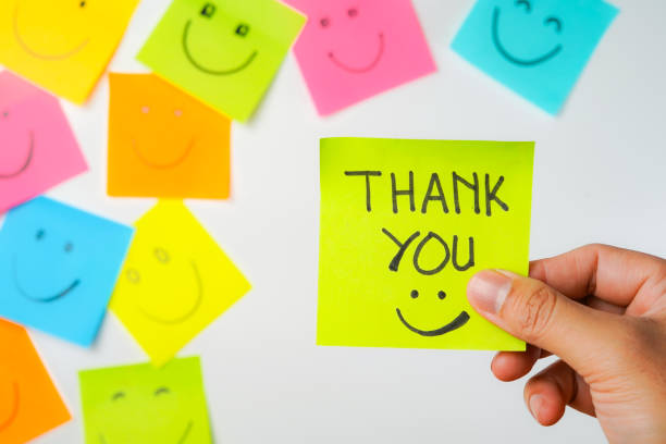 istock Thank you and smile icon inspirational handwriting on sticky notes on hand held 2168016107