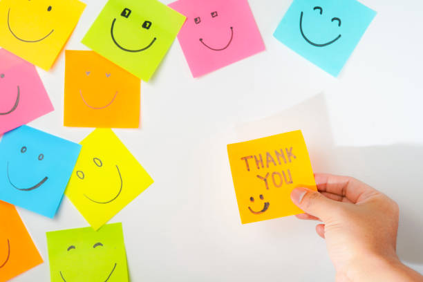 istock Thank you and smile icon inspirational handwriting on sticky notes on hand held 2168016109