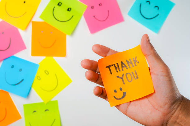 istock Thank you and smile icon inspirational handwriting on sticky notes on hand held 2168016134